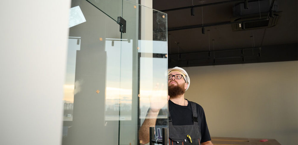 man installing glass shower wall